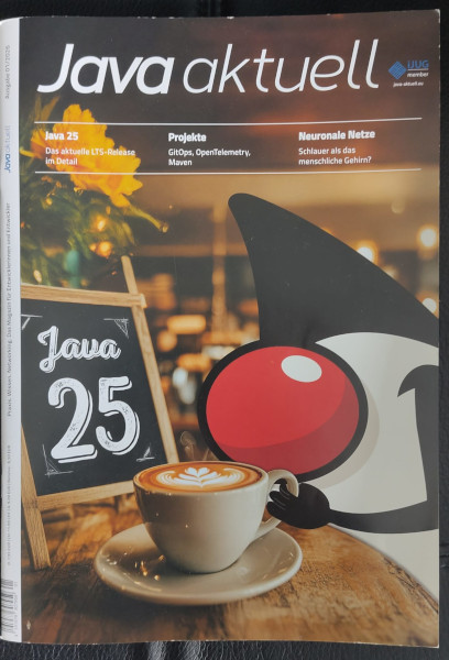 Cover der Java Aktuell: zu sehen ist eine Tasse Kaffe, auf der daneben ein Schild mit Java 25 steht. Dahinter ist das Java Logo