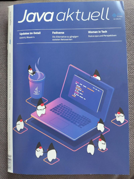 auf dem cover (blauer hintergrund) sieht man einen stilisierten laptop umgeben von 10 java maskotchen und einer Tasse Kaffee mit Java logo